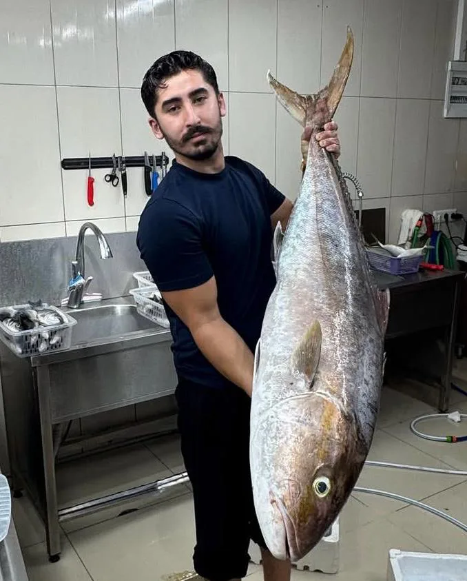 Ekibimizden biri hazırlık alanında iri bir balığı tutuyor